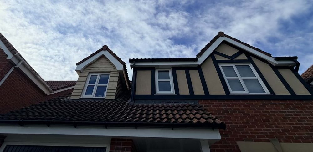 New fascias, soffits and guttering across the front of a detached house with dormer and mock Tudor gables