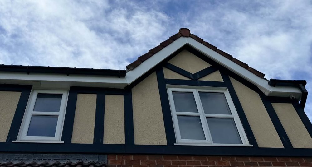 New white bargeboards and dark fascias on a mock Tudor gable